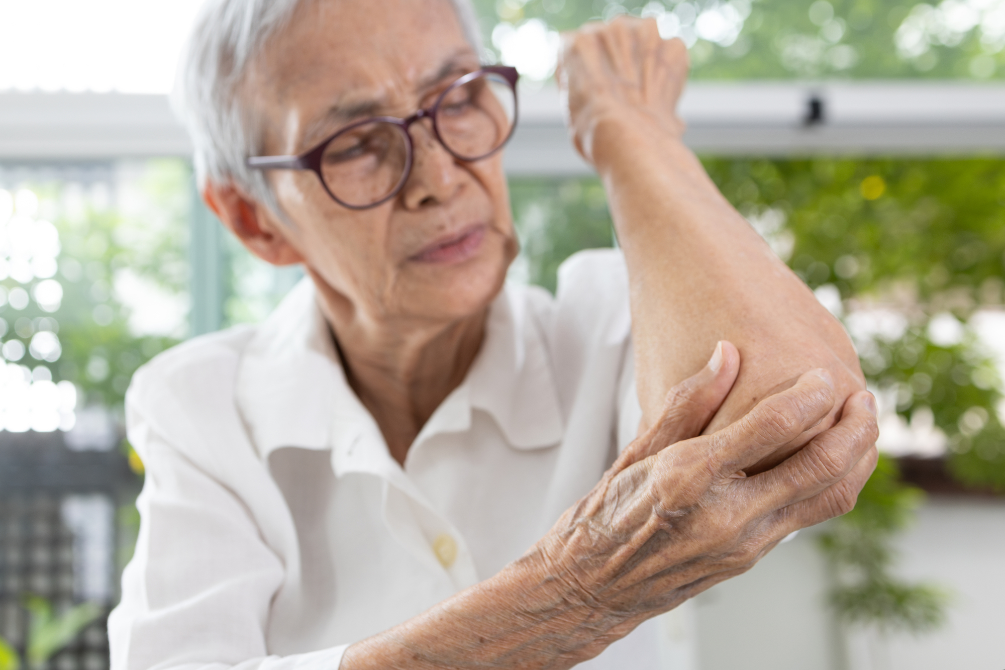 Old Elderly experiencing elbow pain,stiffness and swelling,irritation of joint,painful inflammation of tendons in the elbow,diseases of Rheumatoid Arthritis,Osteoarthritis,Bursitis,health care concept